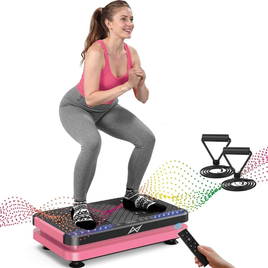 A woman performing a squat exercise on a pink vibration plate while wearing workout attire, with resistance bands and a remote control nearby.