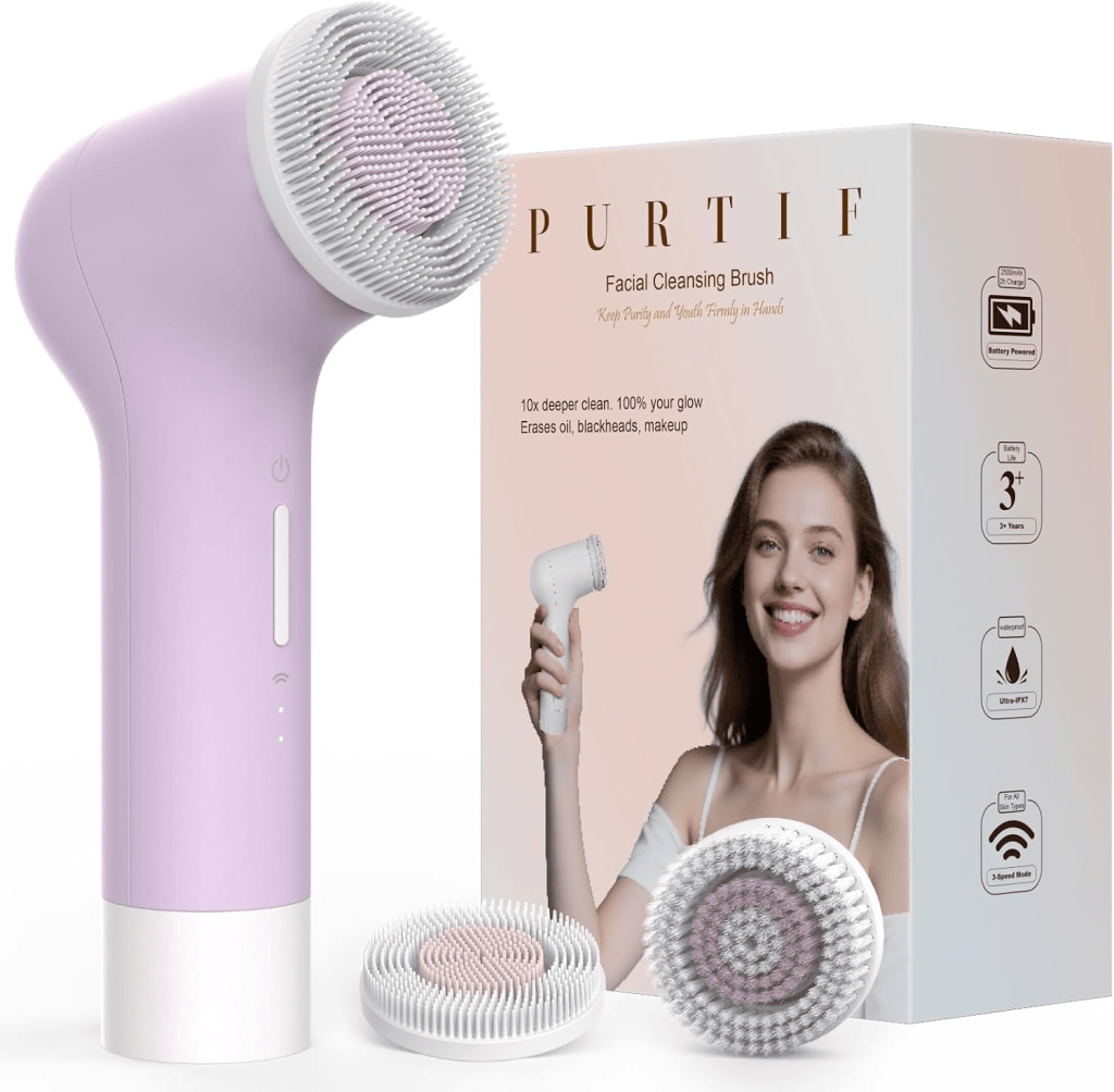 A facial cleansing brush in lavender color beside its packaging, featuring a smiling woman holding the brush. The packaging highlights features like deep cleansing and makeup removal.